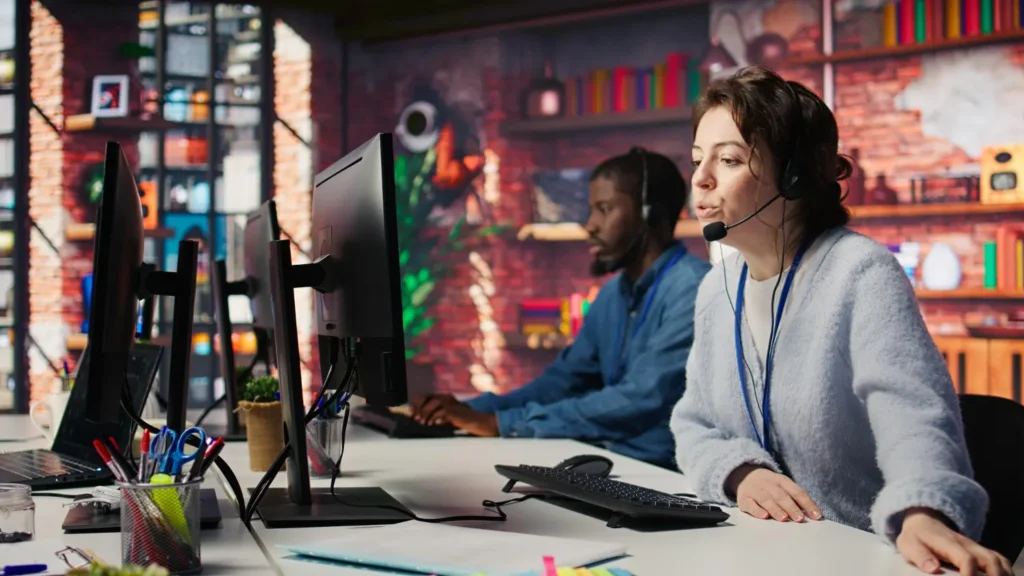 Une équipe de conseillers en centre d'appels avec casques audio travaillant devant des ordinateurs, illustrant la gestion du support client pour un revendeur IPTV.